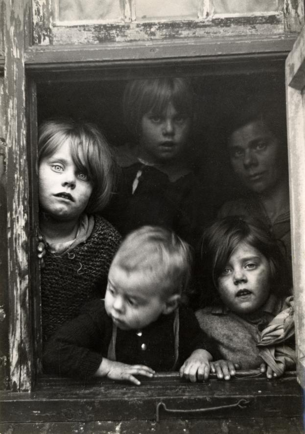 Poor children looking through a window